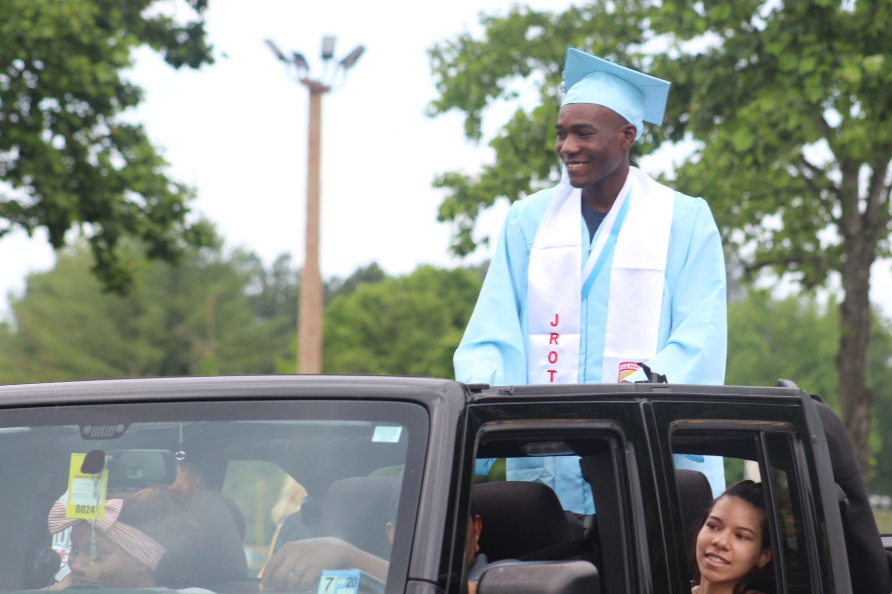 Student riding on top of jeep.JPG